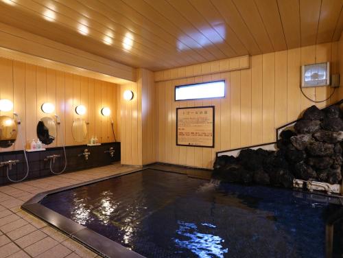 een groot zwembad met water in een kamer met bij Shiga Ichii Hotel in Yamanouchi