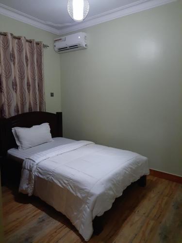Ένα ή περισσότερα κρεβάτια σε δωμάτιο στο Munyonyo Heights Apartments