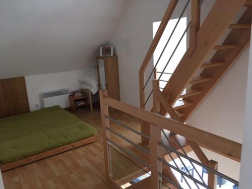 a room with a staircase and a green bed at Gite des 3 cigognes in Colmar