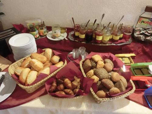 a table with three baskets of bread and other foods at Hotel Garni am Bowenberg in Niederzissen
