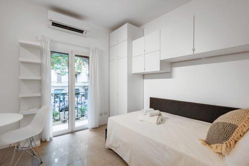 Habitación blanca con cama grande y escritorio. en Wonderful studio in Pta romana 10 mins from Duomo by Easylife, en Milán
