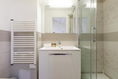 une salle de bain blanche avec un lavabo et une douche dans l'établissement Doris YourHostHelper, à Cannes