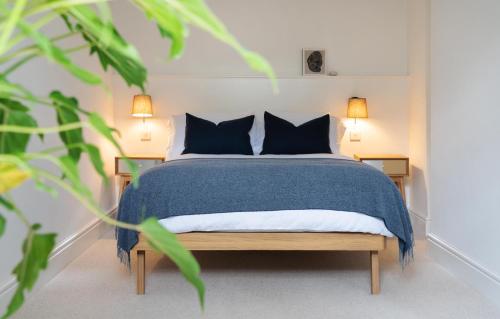 Un dormitorio con una cama con sábanas y almohadas azules. en Deluxe Apartment in Historic Quarter near Beaches, en Aberystwyth