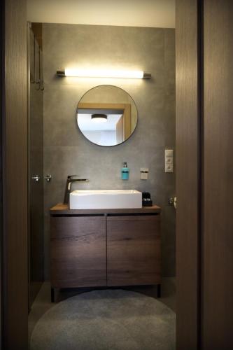 a bathroom with a sink and a mirror at Apartmán Golfballs in Šajdíkove Humence