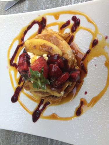 a plate with a dessert with strawberries and syrup at The Lookout Guest House in Port Alfred