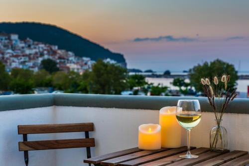 a table with two candles and a glass of wine at Uncle John's Guesthouse in Skopelos Town
