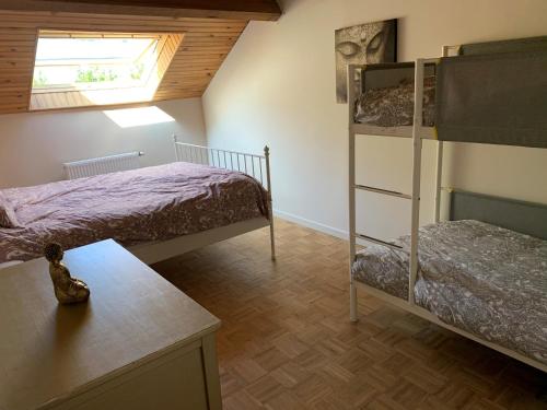 een slaapkamer met 2 stapelbedden en een tafel bij Maison de Rochehaut in Rochehaut