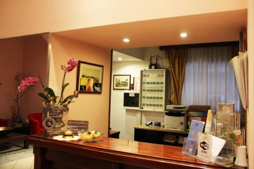 a living room with a counter with flowers on it at Albergo Al Viale in Trieste