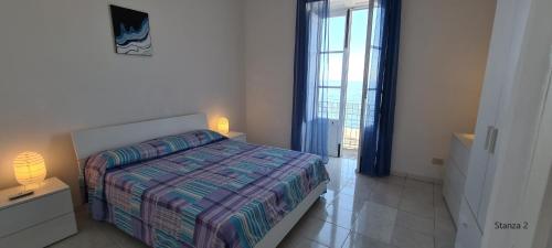 a bedroom with a bed and a large window at La casa sul mare in Lipari
