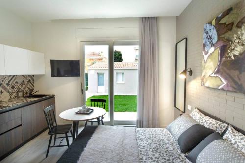 Habitación con cama, mesa y cocina. en Le Stanze Guesthouse, en Morciano di Romagna