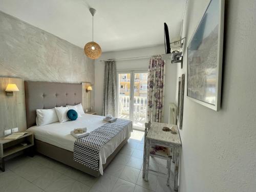 a hotel room with a bed and a window at VANA Studios & Apartments in Limenaria