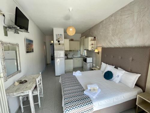 a small bedroom with a bed and a kitchen at VANA Studios & Apartments in Limenaria