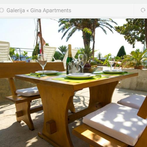 a wooden table with plates and glasses on it at Apartments Gina in Trogir