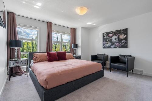 a bedroom with a bed and two chairs in it at Luxury Spacious Private House near City Centre in Calgary