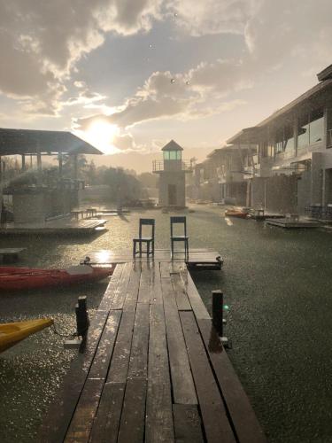 a dock with two chairs sitting on top of a body of water at The Oia Pai Resort in Pai