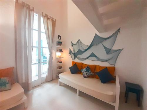 Habitación con sofá y pintura en la pared en App Rosanna, Estoril Beach, 2steps from the sea, Free Wi-Fi & AC, en Sal Rei
