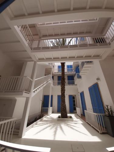 a palm tree in the middle of a building at App Rosanna, Estoril Beach, 2steps from the sea, Free Wi-Fi & AC in Sal Rei