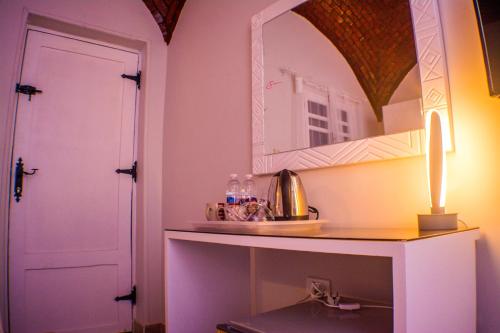 um quarto com uma mesa com um espelho e uma porta em NUB INN em Aswan
