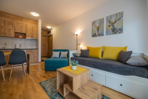 a living room with a couch and a kitchen at Studio apartman Anja in Zlatibor