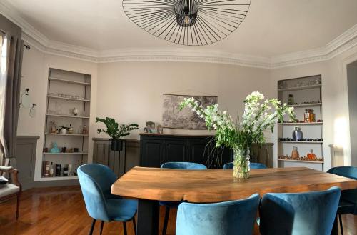 une salle à manger avec une table en bois et des chaises bleues dans l'établissement Chambre au petit Chateau, à Tourcoing