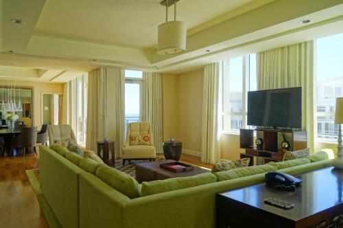 sala de estar con sofá y TV en Presidential Penthouse Suite, en Riviera Beach