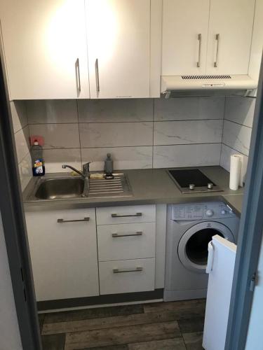 une cuisine avec un évier et une machine à laver dans l'établissement Résidence La Miougrano Fréjus plage, à Fréjus