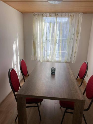 a dining room table with chairs and a remote control on it at Dorfschenke in Siegen