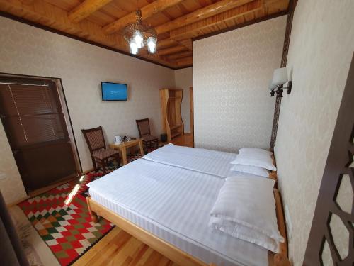 a bedroom with a large white bed in a room at Khiva Siyovush Hotel in Khiva