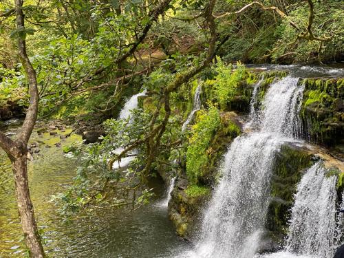 a waterfall on the side of a river at The Cwtch, Log Fire, Sleeps 6, Nr Zip World, Brecon and Bike Park Wales in Aberdare