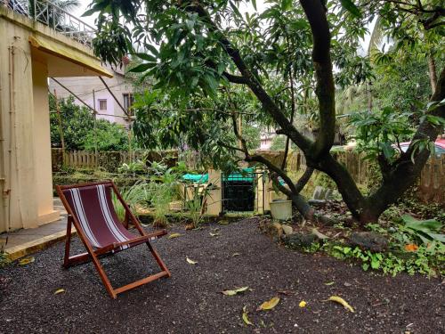 una silla sentada en un patio junto a un árbol en Sakhey Homestay, en Ratnagiri