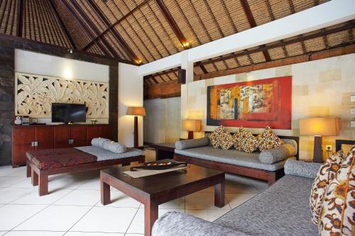 a living room with two couches and a tv at The Maya Seminyak Villas in Seminyak