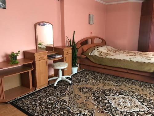 Schlafzimmer mit einem Bett, einem Schreibtisch und einem Spiegel in der Unterkunft Апартаменти з окремою ванною кімнатою in Czernowitz