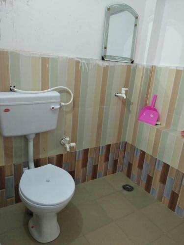 a bathroom with a white toilet and a mirror at Aashirwad Garden & Resort in Pilani