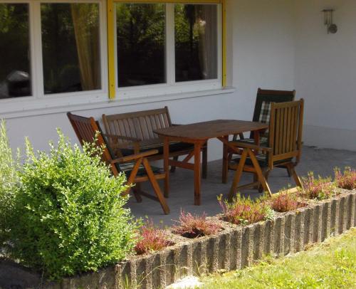 a wooden table and chairs in front of a house at Ferienwohnung Knobloch in Wahlheim