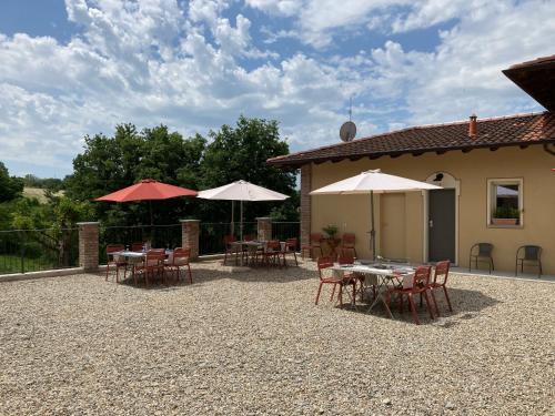 a patio with tables and umbrellas in front of a building at La Corte Nascosta Volpedo in Volpedo