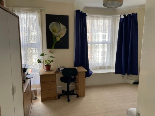 a room with a desk, chair and a window at Friendly house in London