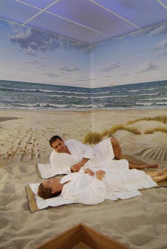 a man and a woman laying on the beach at Hotel Spiekeroog in Spiekeroog