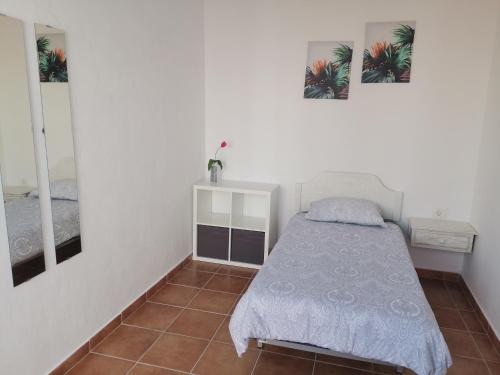 a small bedroom with a bed and two mirrors at Casa Rural Leo: remanso de paz y tranquilidad in Agulo