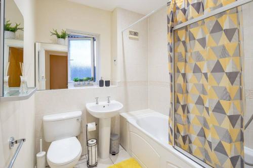 a bathroom with a toilet and a sink and a bath tub at Cozy 2 bed room Flat Walking distance from ExCel in London