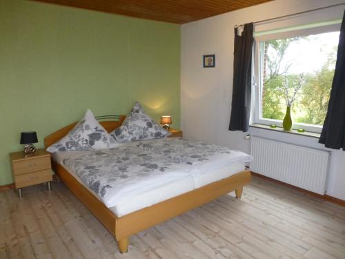 a bedroom with a bed and a large window at Omas oll Huus in Norden