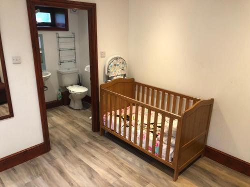 a baby room with a crib and a toilet at Ochiltree cottage in Newton Stewart