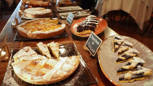 a table with many different types of cakes and pies at Le Querce Hotel in Salsomaggiore Terme