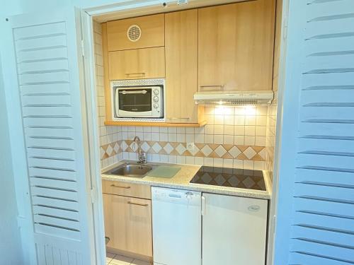a small kitchen with a sink and a microwave at Val Claret, Tignes T2 tout confort de 36m2 in Tignes