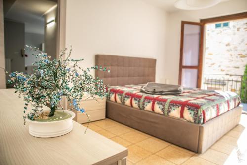松德里奧的住宿－Residenza Zoia，一间卧室配有一张床和一张植物桌子