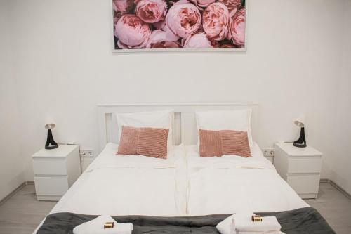um quarto com duas camas com rosas cor-de-rosa na parede em FodorMenta Residence em Eger