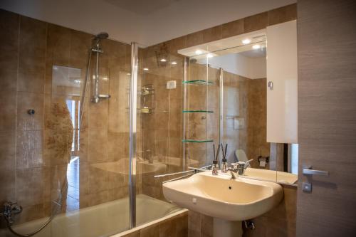 een badkamer met een wastafel en een douche bij Residenza Zoia in Sondrio