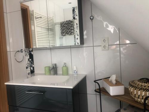 a bathroom with a sink and a mirror at Ferienwohnungen Margot in Iserlohn