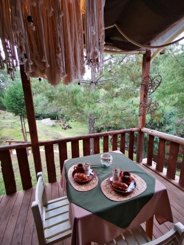 a table with two plates of food on a porch at Luchita Mia Eco Cabañas Boutique in Zacatlán