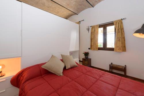 a bedroom with a red bed with a window at colosseo flats and penthouse in Rome