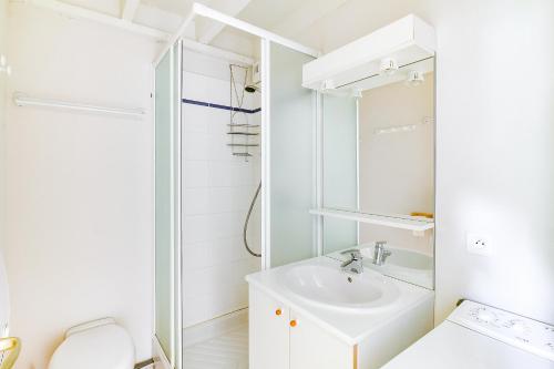 a white bathroom with a sink and a toilet at Chalet de Peyrelance in Cauterets